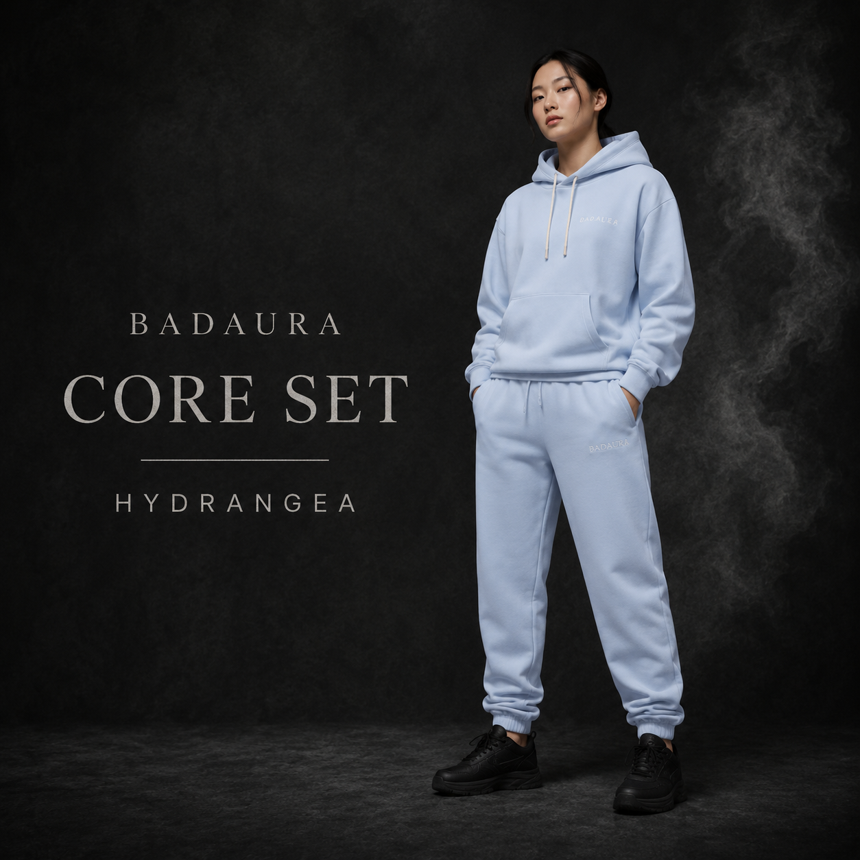 Person wearing a light blue hoodie and pants with 'Badaura Core Set Hydrangea' text on a dark background.